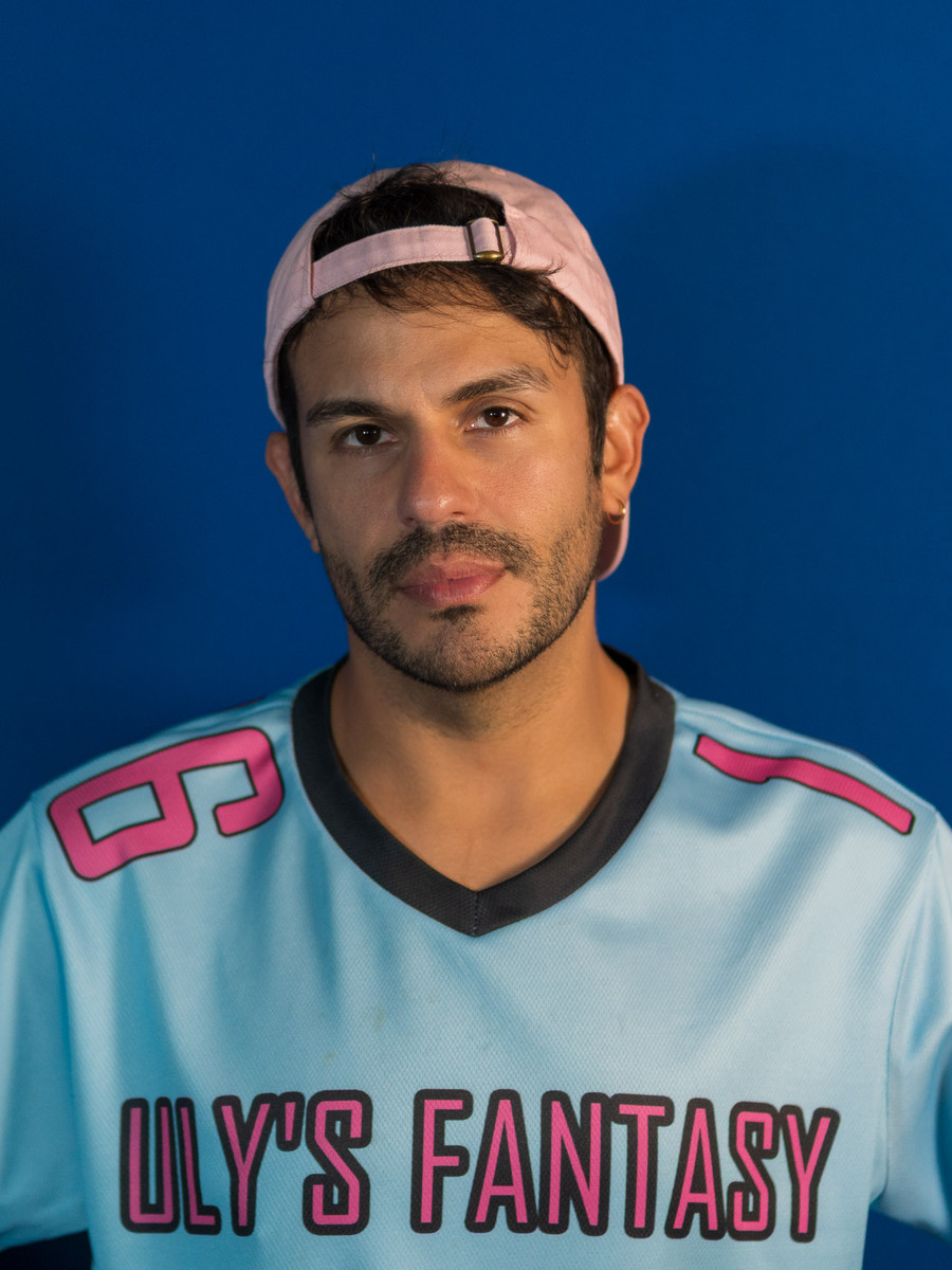 Uly, the Head Hottie — deadpan media-day portrait, jersey on, staring down the camera.